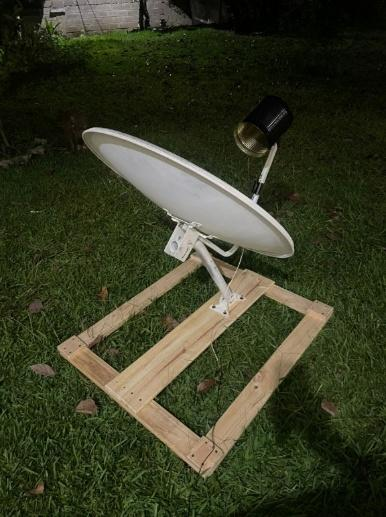 Antena parabólica sobre un marco de madera con el feedhorn de lata en el foco