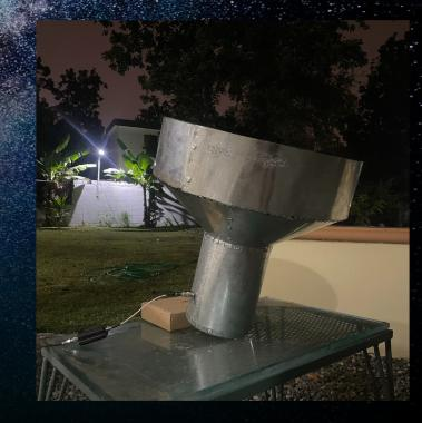 Feedhorn cónico de lámina metálica sobre una mesa, de noche