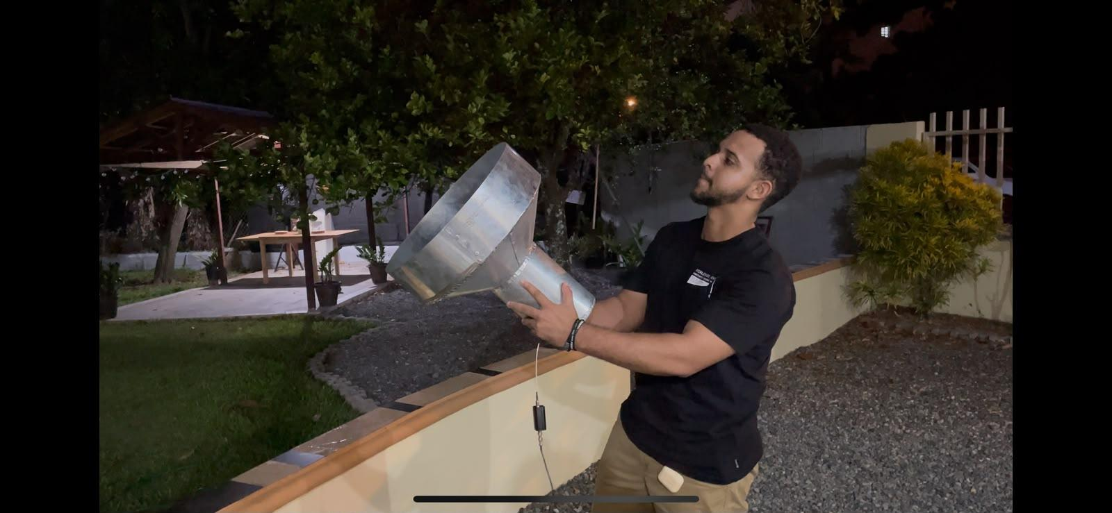 Uno de los estudiantes sostiene el feedhorn cónico apuntándolo hacia el cielo nocturno